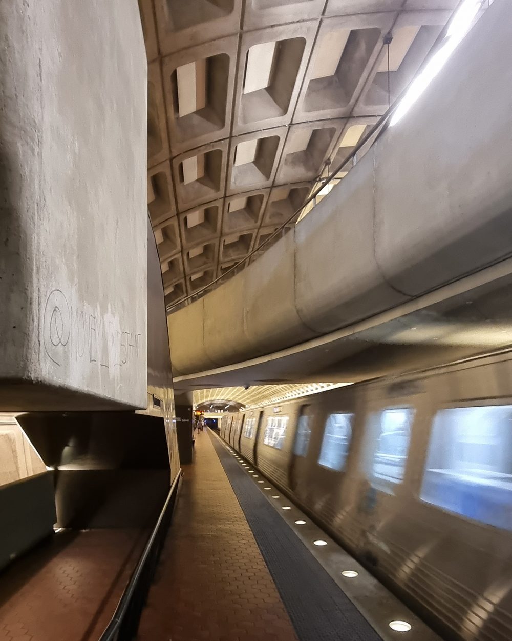 A train pulling into a concrete brutalist metro station
